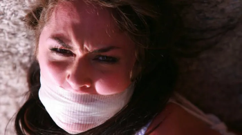 Holly Nicole is a Tightly Hogtied, Massively Gagged, Toe-tied & Very Frustrated Victim of a Fugitive on the Run! RE EDIT.webp