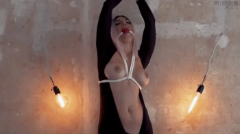 Olga in catsuit is tied to the wall and completely wetting herself in drool FullHD.webp