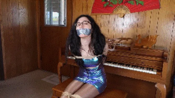 Khrystal the famous pianist, wearing a cosmic dress, tied and gagged by a jealous pianist who wants to ruin her career!.webp