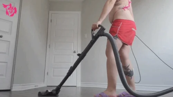 Giantess in shorts and bikini vacuums and mops while you hide in a corner.webp