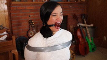 Raven Lynette tied during an undercover mission, first gagged with ballgag then mouth heavily stuffed and wraparound gag.webp