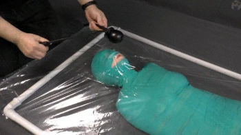 Mummification bandage vibrator and inflatable gag in a vacuum bed.webp