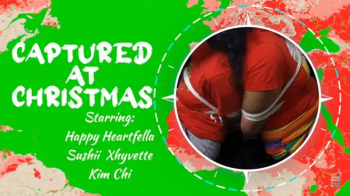 Captured At Christmas - Starring- Kim Chi, Sushi Xhyvette, Happy Heartfella - Kim and Sushii are magically bound and gag.webp